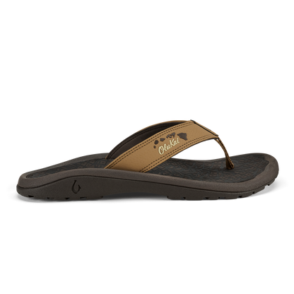 Tan leather thong sandal with black sole and island chain design detail on strap.