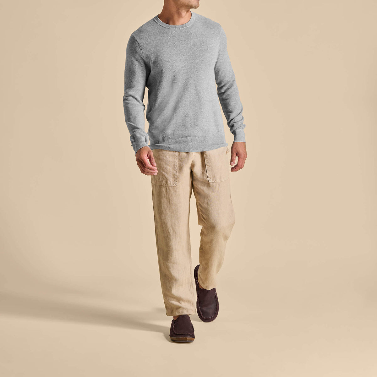Man wearing gray long-sleeve shirt, beige cargo pants, and dark brown suede slippers.