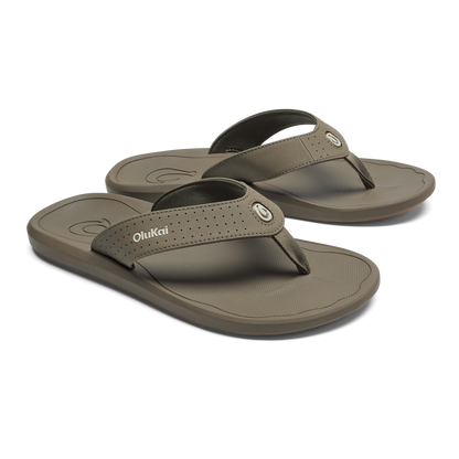 Pair of walnut-colored OluKai Ki'i flip-flop sandals with textured straps and contoured footbeds.