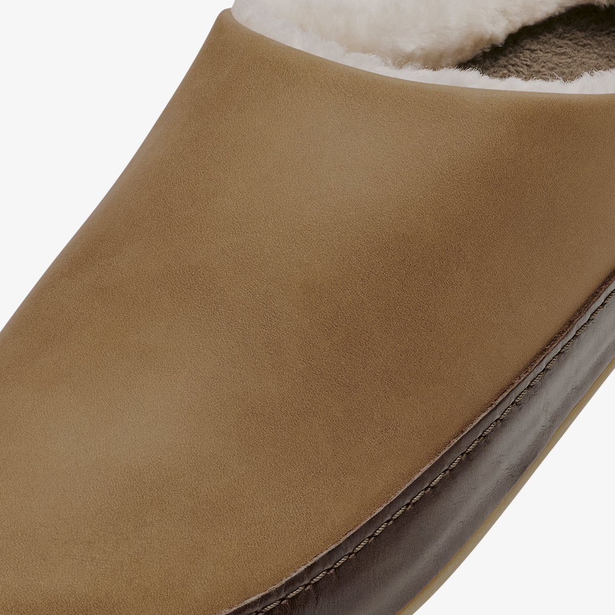 Toffee-colored suede slipper with dark java sole and white sherpa lining visible at the cuff.