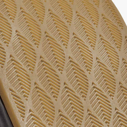 Tan fabric with geometric chevron and linear embossed pattern, edge of gray material visible at bottom.