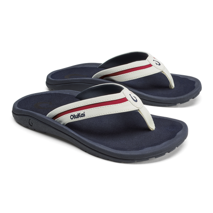 Pair of dark navy thong sandals with white and red striped straps and cushioned footbeds.