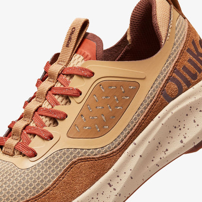 Makiki sneaker with tan mesh upper, carob brown suede panels, red laces, perforated tan midsole, and textured brown heel acce