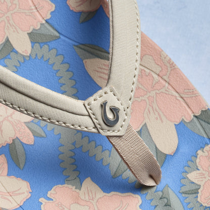 Cream handle with metal clasp detail on tapa fabric tote featuring pink, blue, and gray floral pattern.