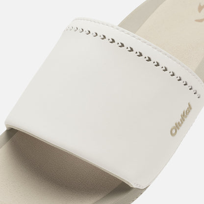 White slide sandal with studded edge detail and beige fabric upper strap.