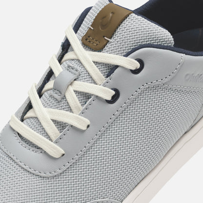 Grey and tan lace-up sneaker with mesh upper, leather overlay, and cream laces, shown from angled side view.