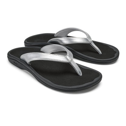 Pair of black flip-flops with silver metallic thong straps and cushioned soles.